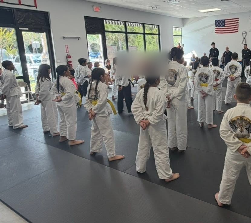 Empower Martial Arts Academy after school kids standing at attention in a group formation with certified instructors during a daily martial arts class in Lake Worth FL
