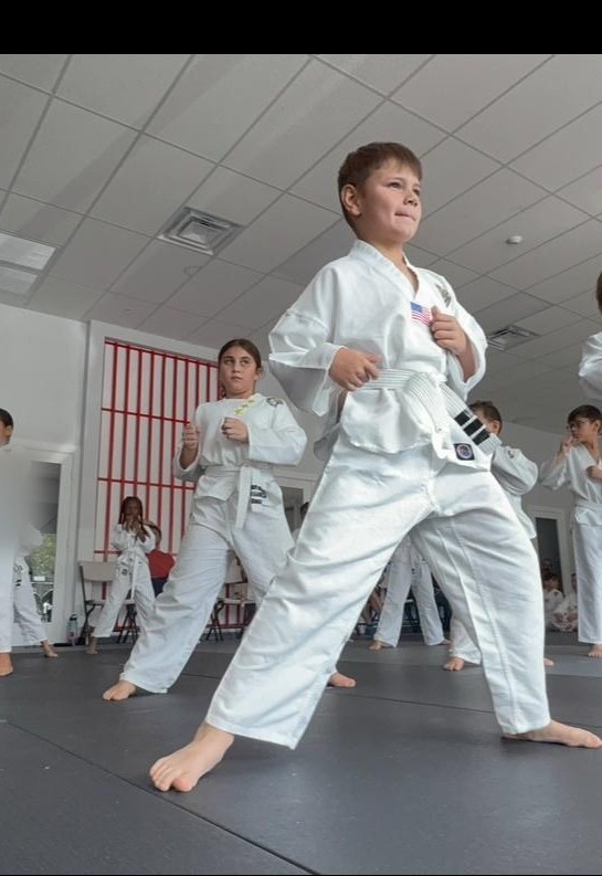 Empower Martial Arts Academy black belt student holding a focused fighting stance during an after school martial arts class in Lake Worth FL