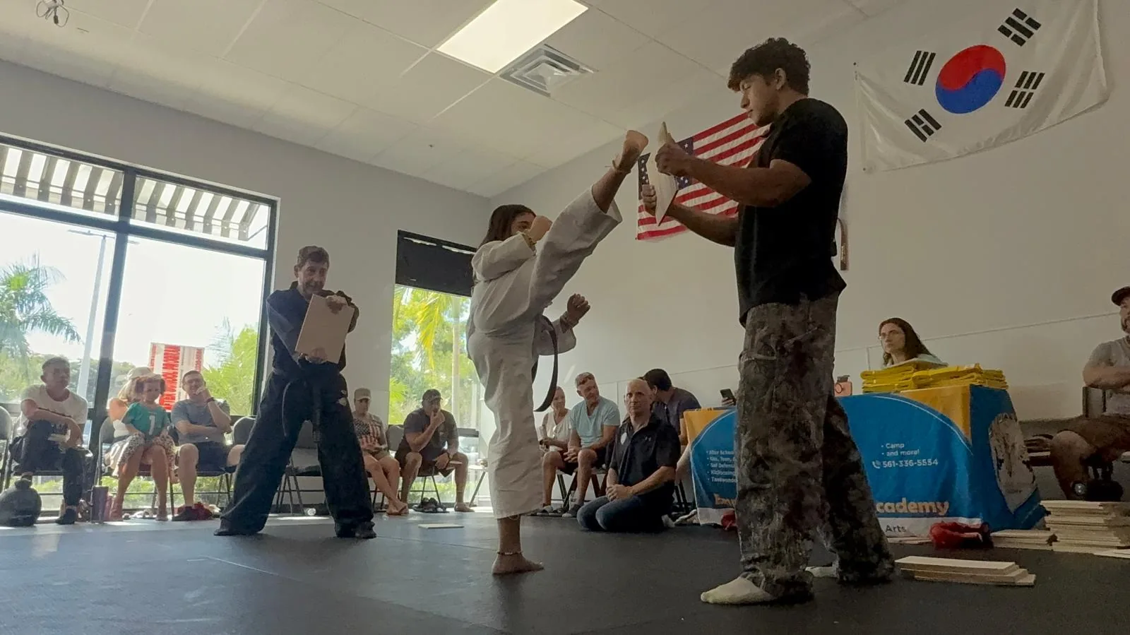 Student breaking board with side kick at Empower Martial Arts