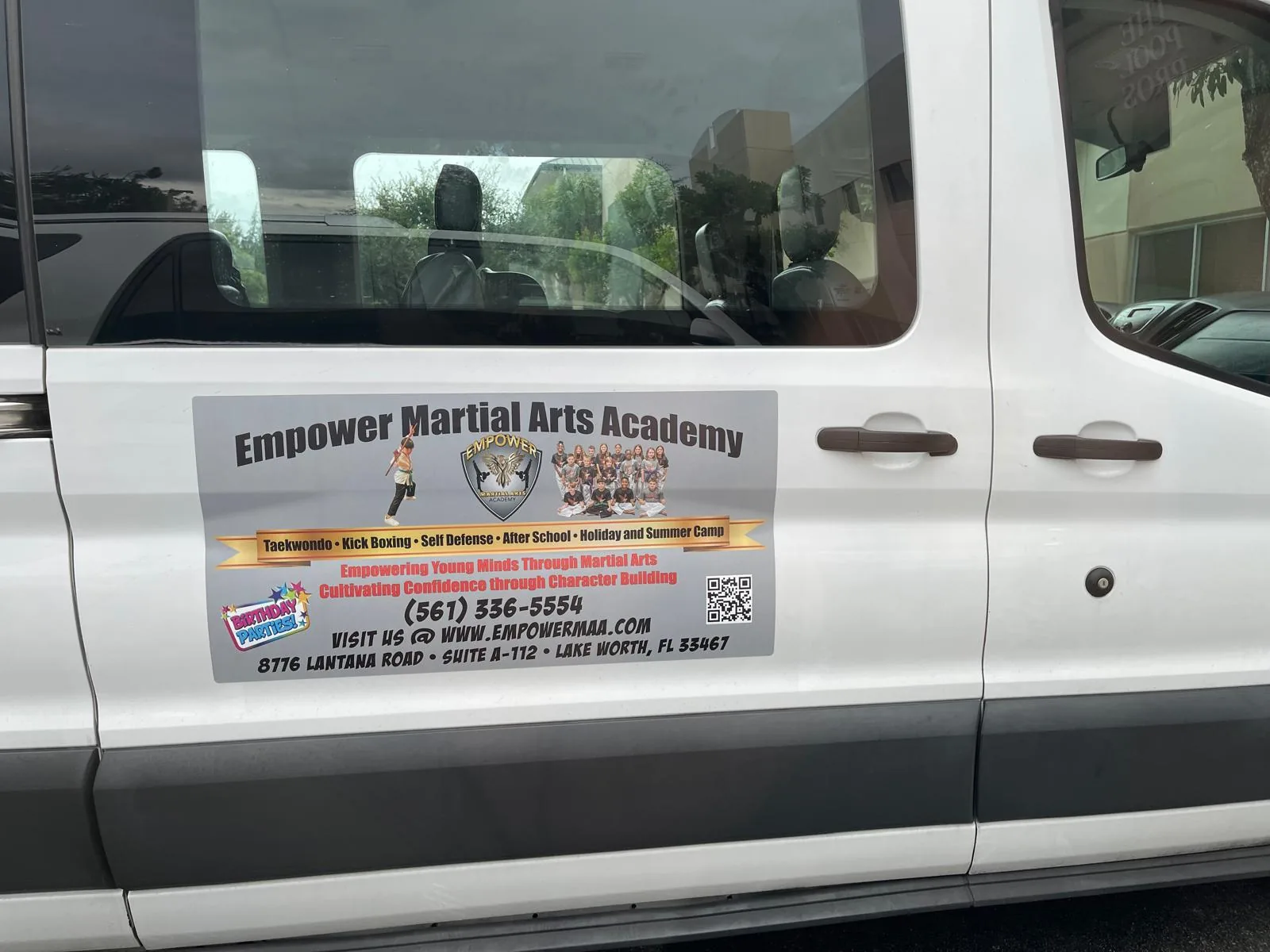 Empower Martial Arts white van side door with contact info and QR code