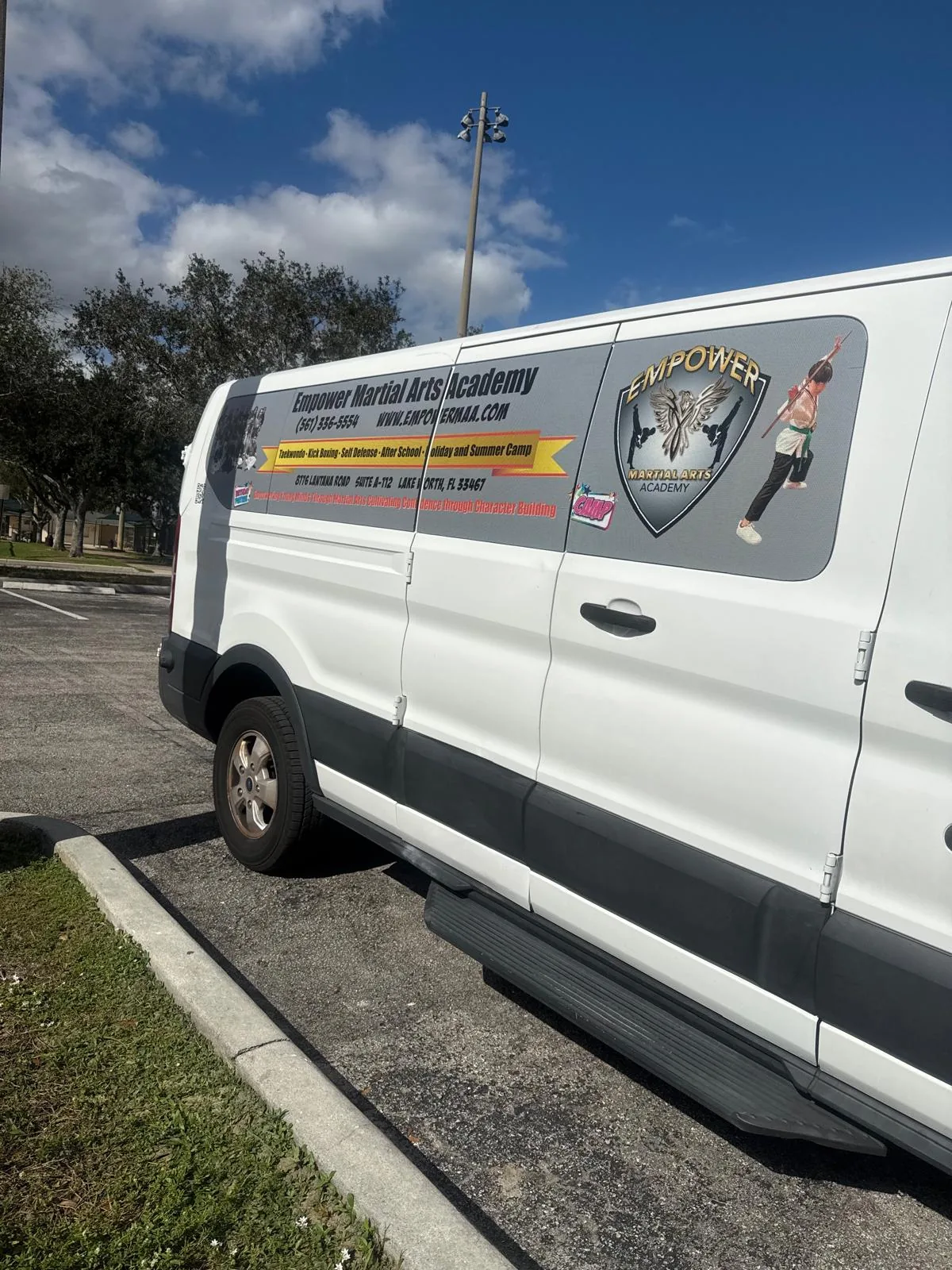 Empower Martial Arts white transport van with academy branding
