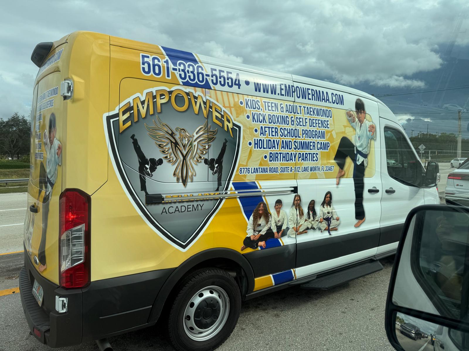 Empower Martial Arts Academy children transportation van #3 — full-wrap yellow Ford Transit van with logo, programs list and 561-336-5554 phone number, for Lake Worth after school pickup